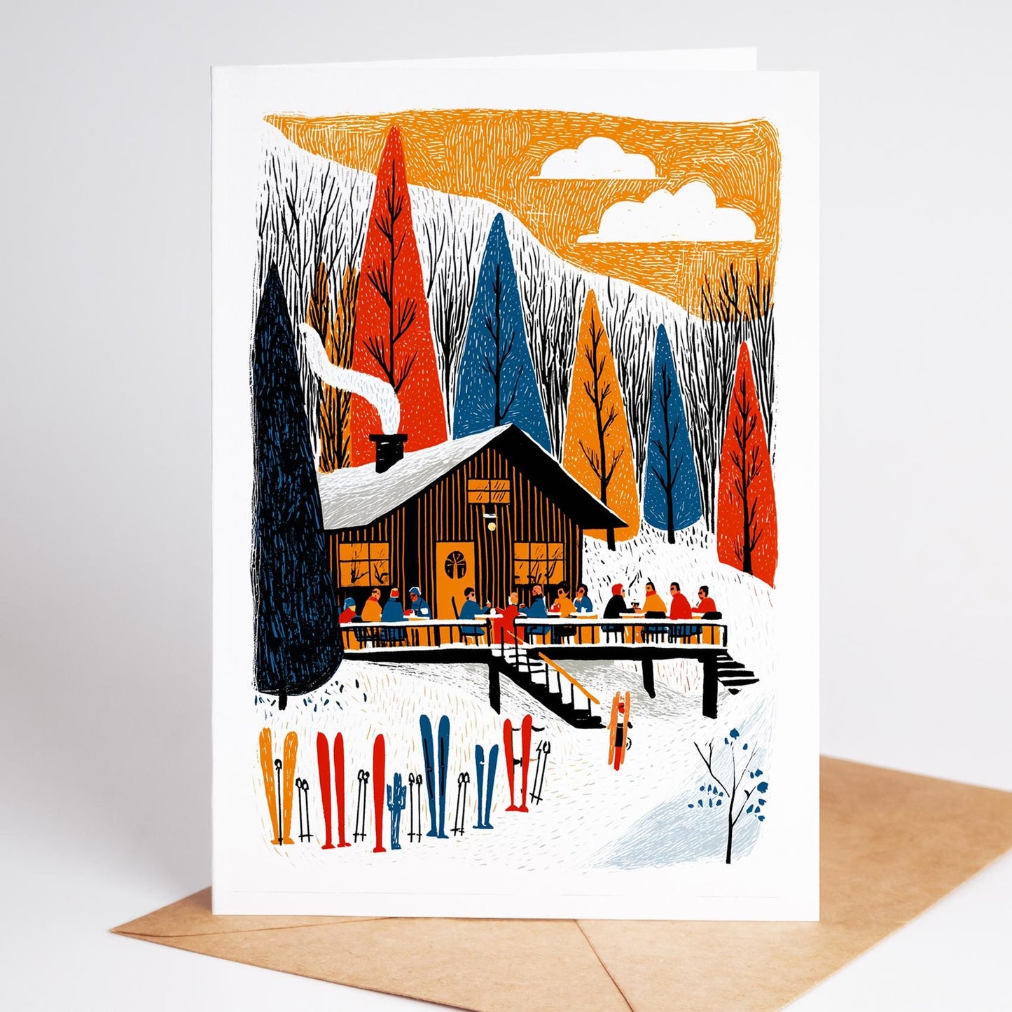 Illustrated winter scene with a cabin, trees, and skiers on a greeting card.