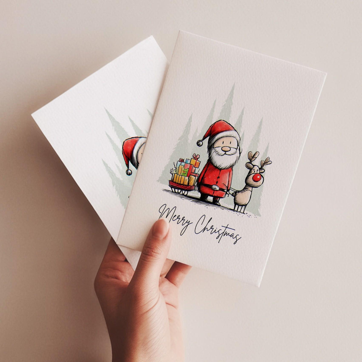 Hand holding two Santa and reindeer Christmas cards