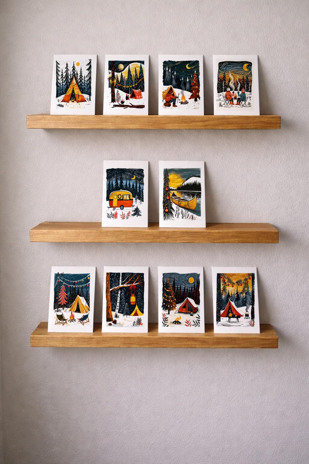 Camping Christmas cards displayed on three wooden shelves