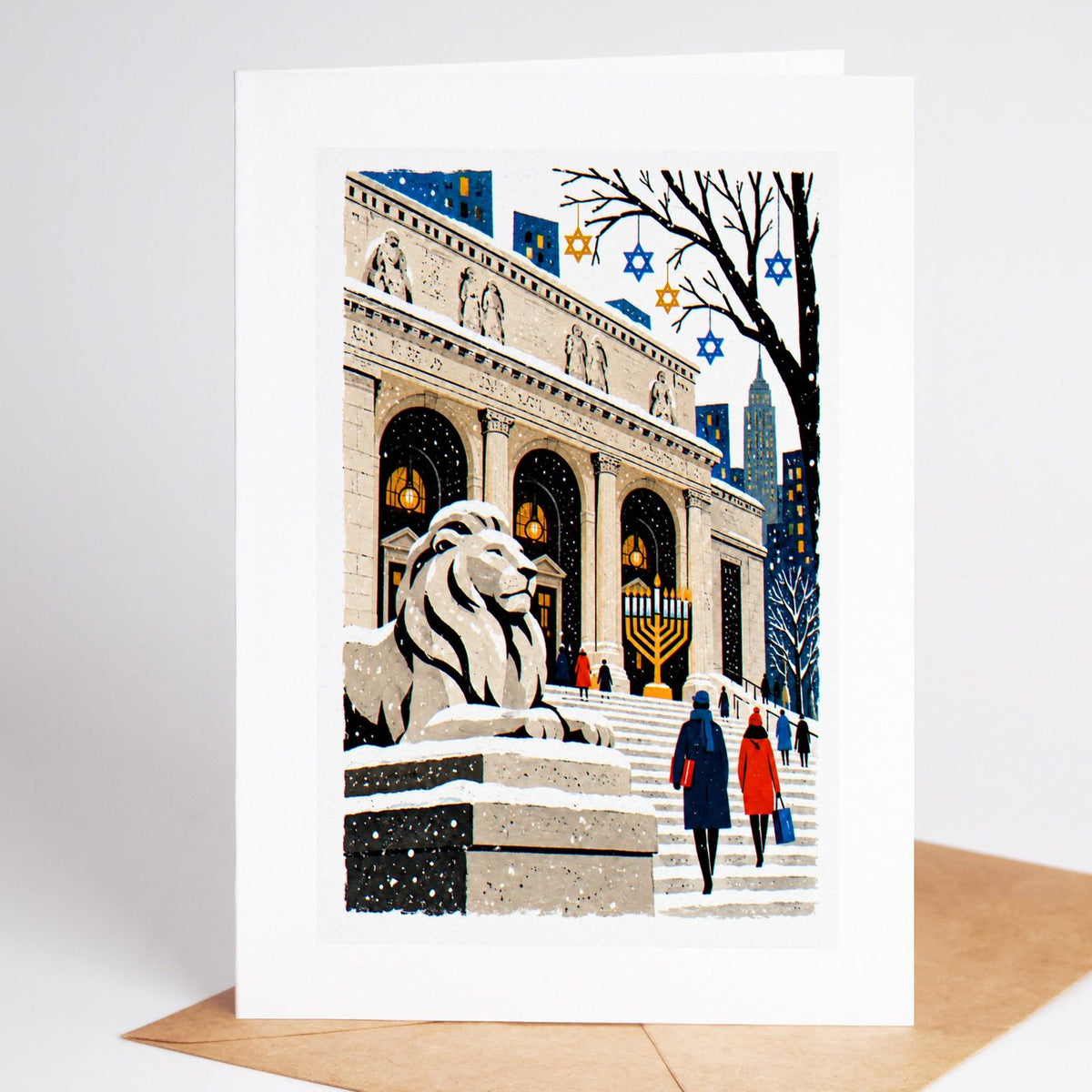 New York Hanukkah card standing with envelope, the library lions in the snow with a lit menorah on the steps
