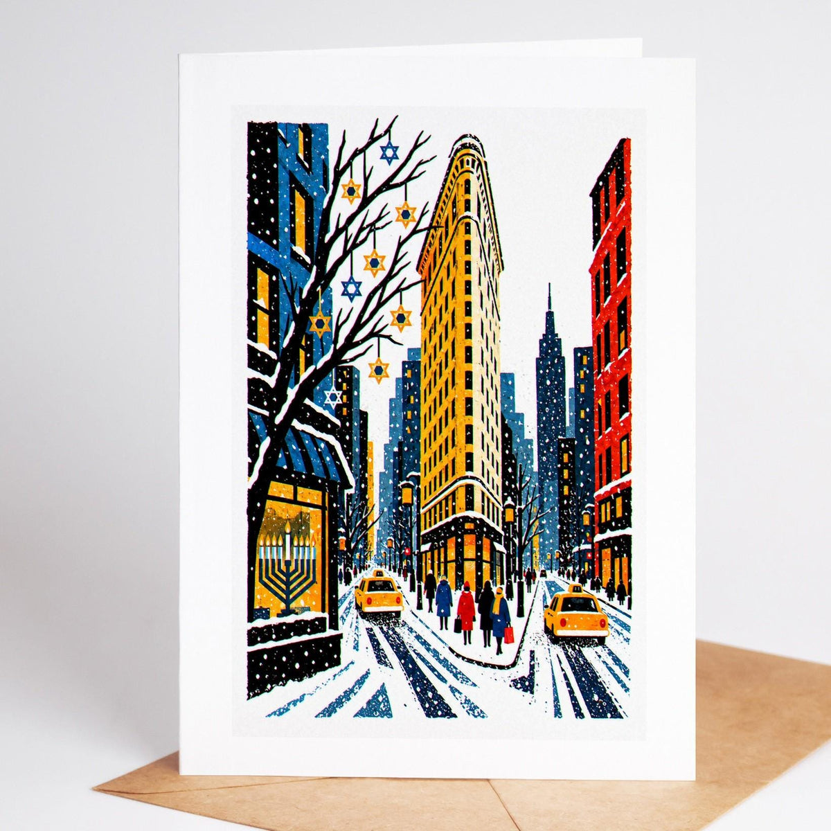New York Hanukkah card standing with envelope, the Flatiron Building in the snow with a lit menorah in a window
