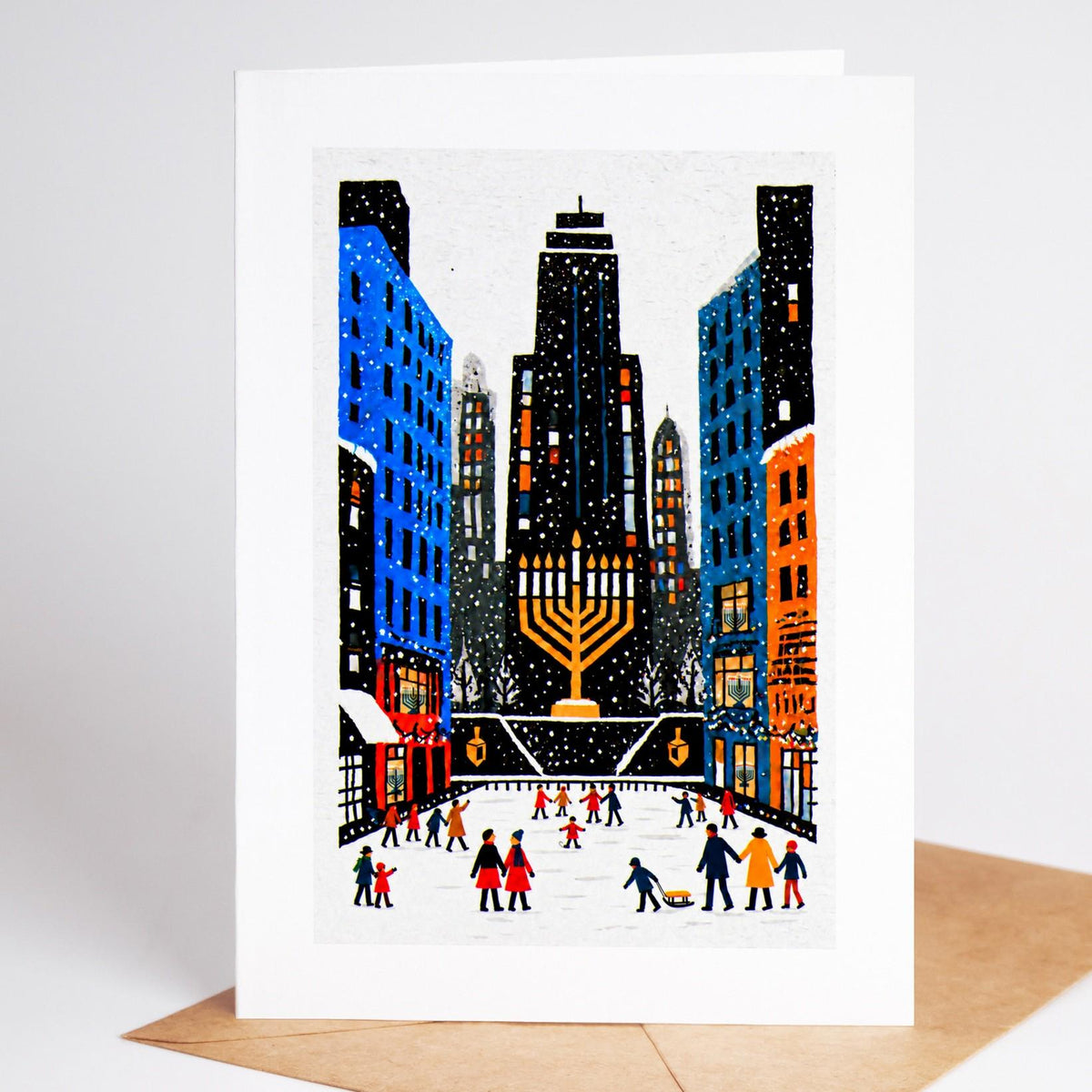 New York Hanukkah card standing upright, skaters below the city towers with nine lights burning above them