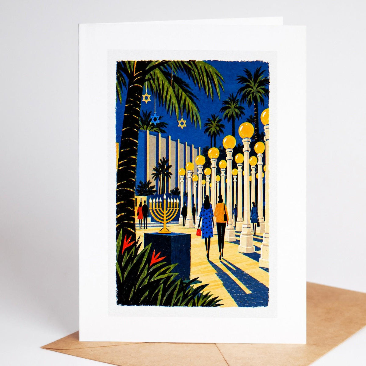 Los Angeles Hanukkah card standing upright, the Urban Light lamp posts with a tall lit menorah beside them