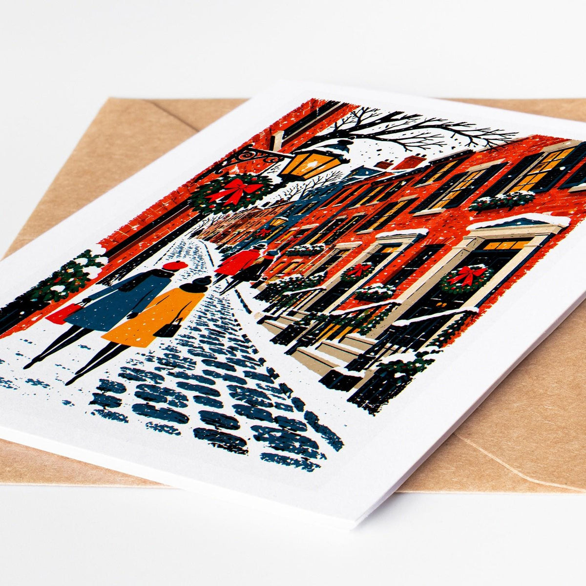 Boston Christmas card lying on a kraft envelope, folk art Beacon Hill gas lamps and brick row houses under snow