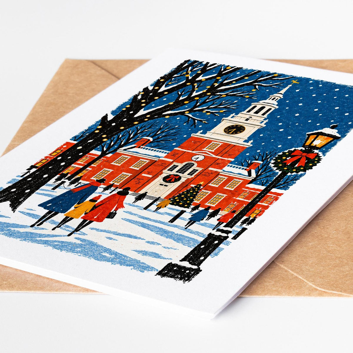 Philadelphia Christmas card lying on a kraft envelope, folk art Independence Hall in the snow with a decorated tree