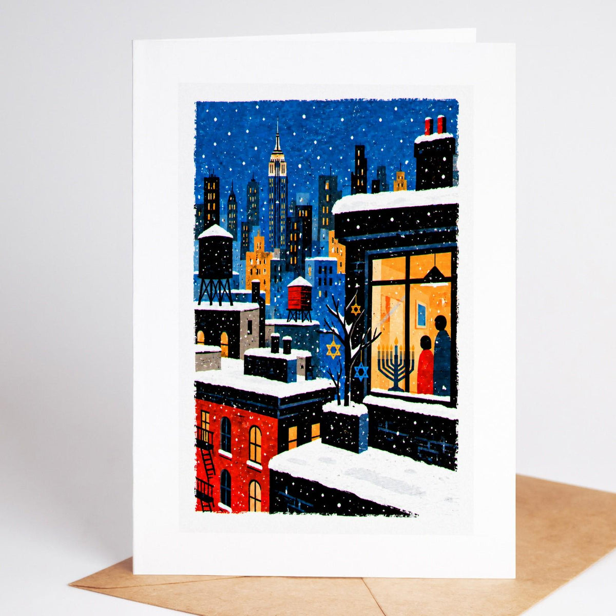 New York Hanukkah card standing upright, a snowy rooftop of water towers with a lit menorah in a window
