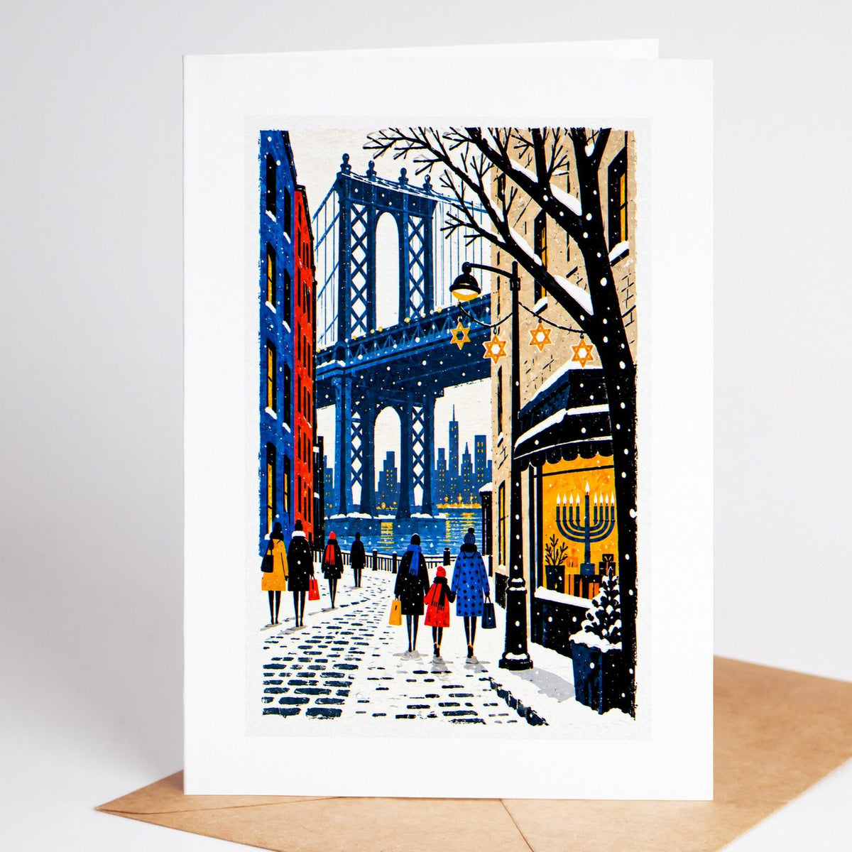 Brooklyn Hanukkah card standing with envelope, DUMBO under the Manhattan Bridge with a lit menorah in a shop window