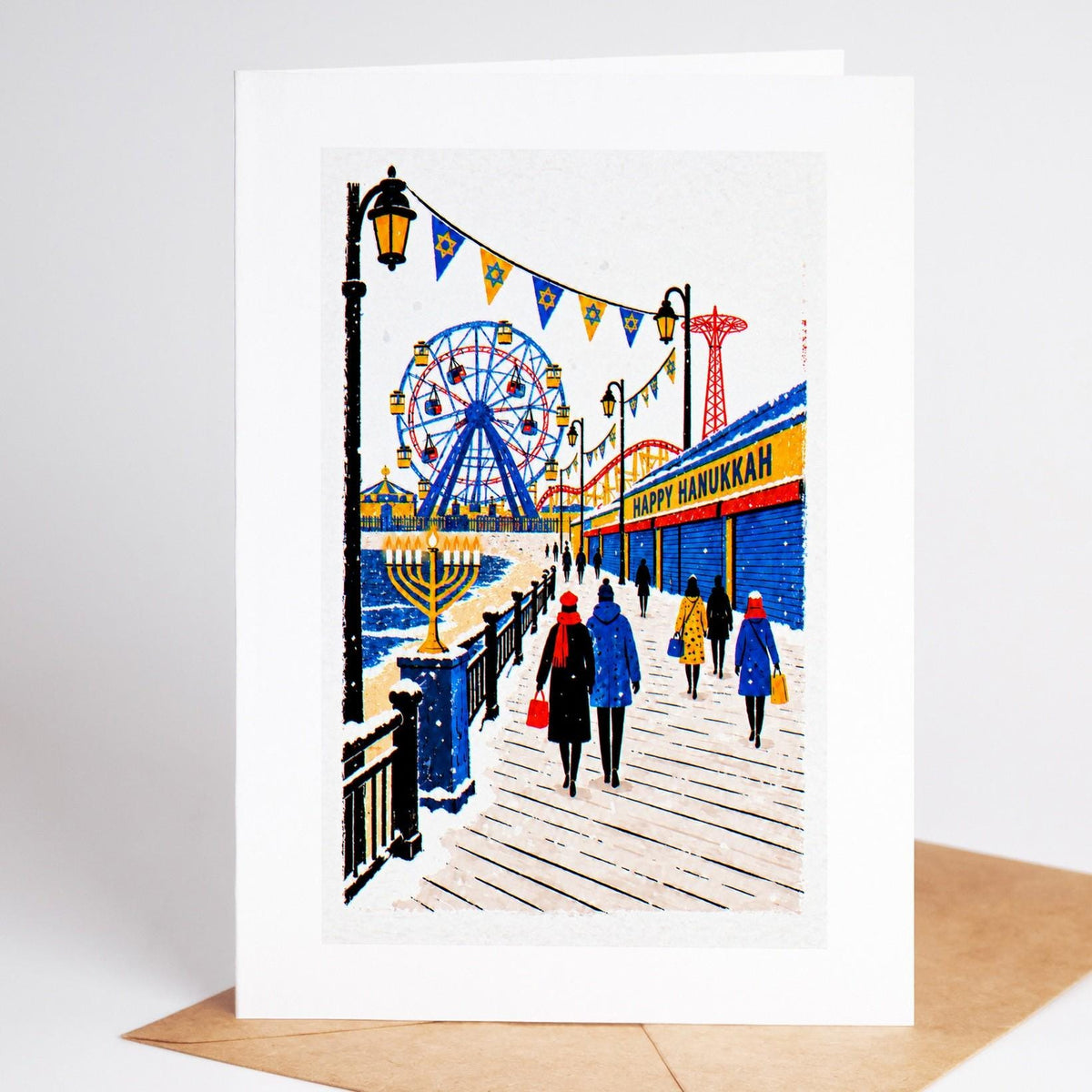 Brooklyn Hanukkah card standing upright, the Coney Island boardwalk under a Happy Hanukkah banner with a lit menorah