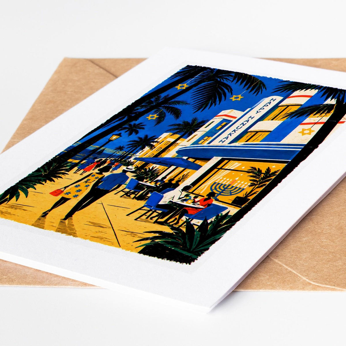 South Florida Hanukkah card lying on a kraft envelope, folk art Ocean Drive art deco hotel with a Happy Hanukkah sign an