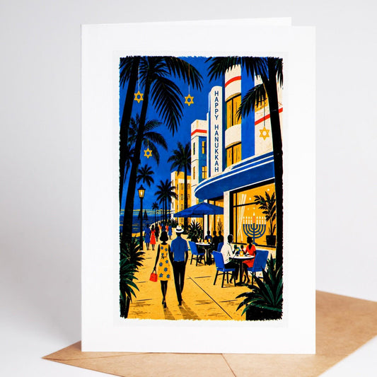 South Florida Hanukkah card standing with envelope, an Ocean Drive art deco hotel with a Happy Hanukkah sign and a lit m