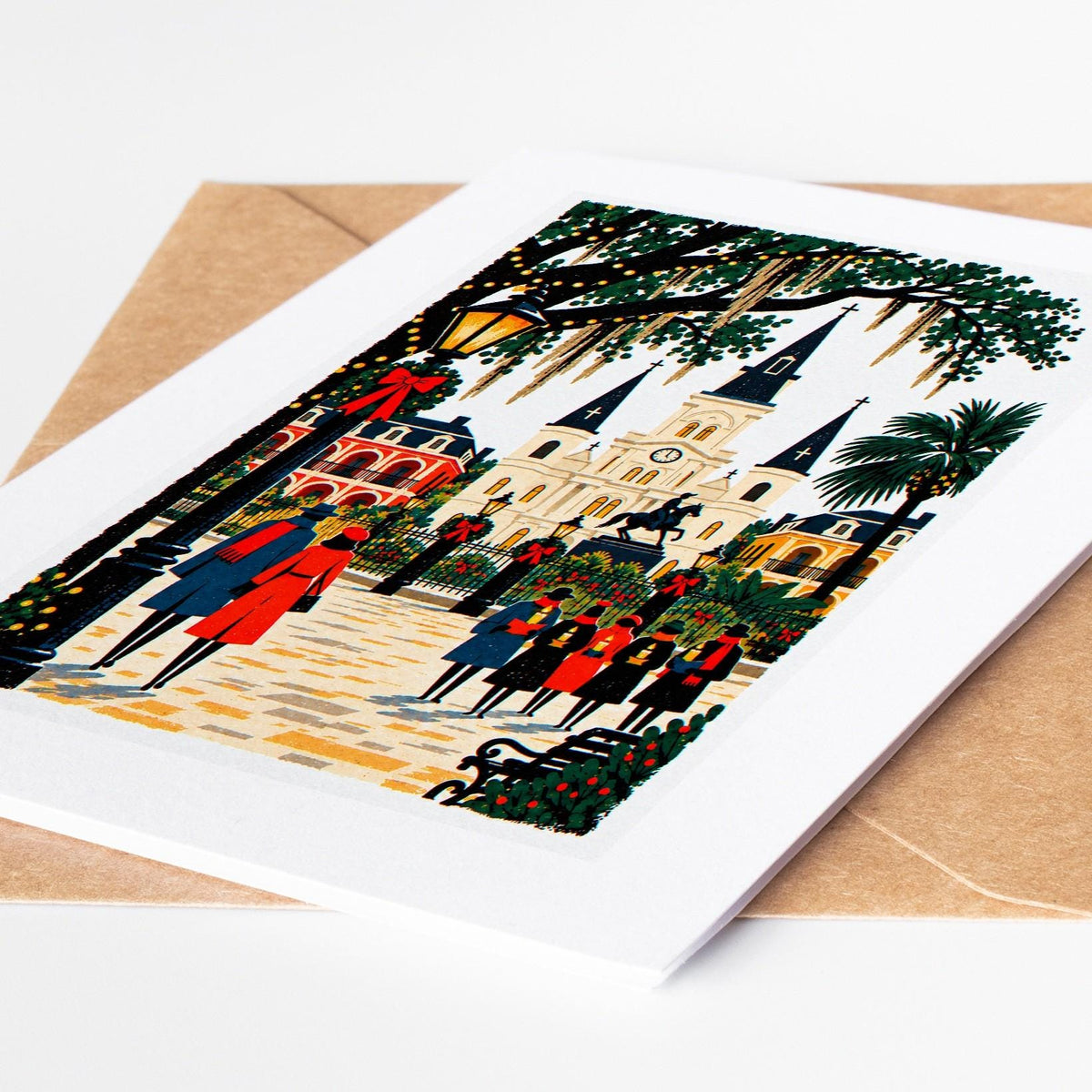 New Orleans Christmas card lying on a kraft envelope, folk art Jackson Square and St Louis Cathedral decked for the holi